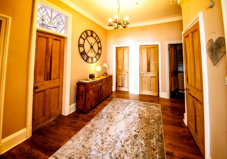 The Hallway at Gourock Seaview Holiday Let with a view with side table and large clock on the wall