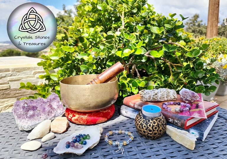 a singing bowl and crystals stones bracelets and Amethyst crystals on a table