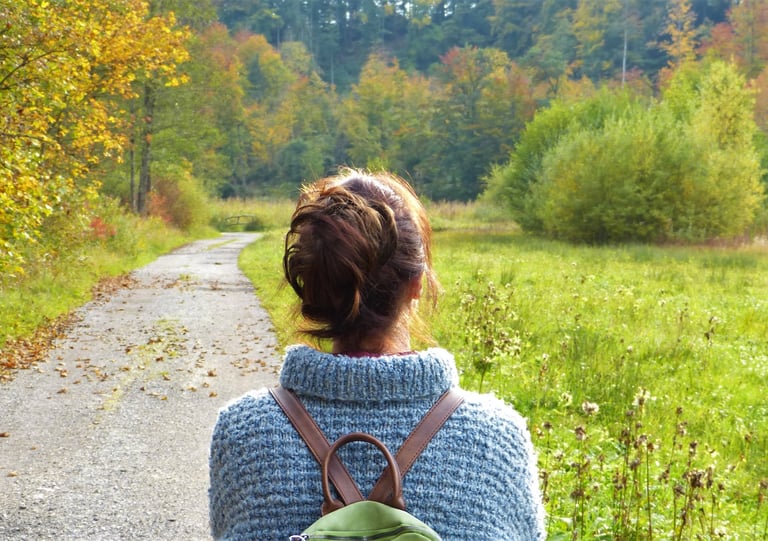 Femme de dos se promenant dans la nature.