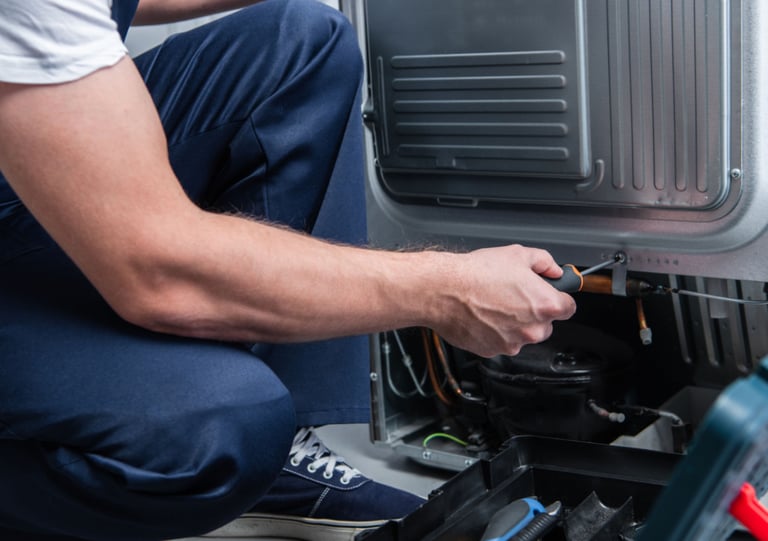 a man in a white shirt is fixing a machine