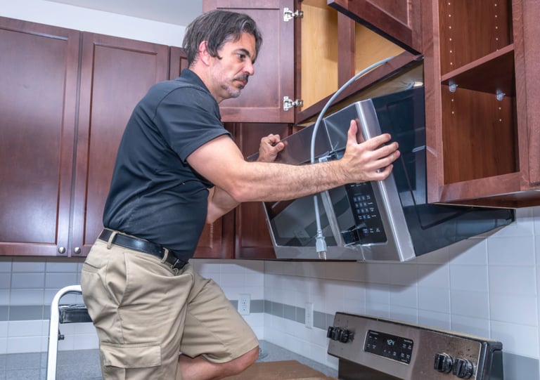 a man is standing in front of a microwave