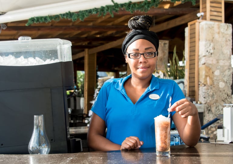 a woman in a blue shirt is holding a drink