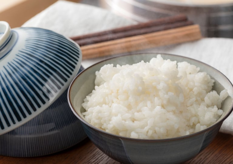 a bowl of rice with chopsticks and chopsticks