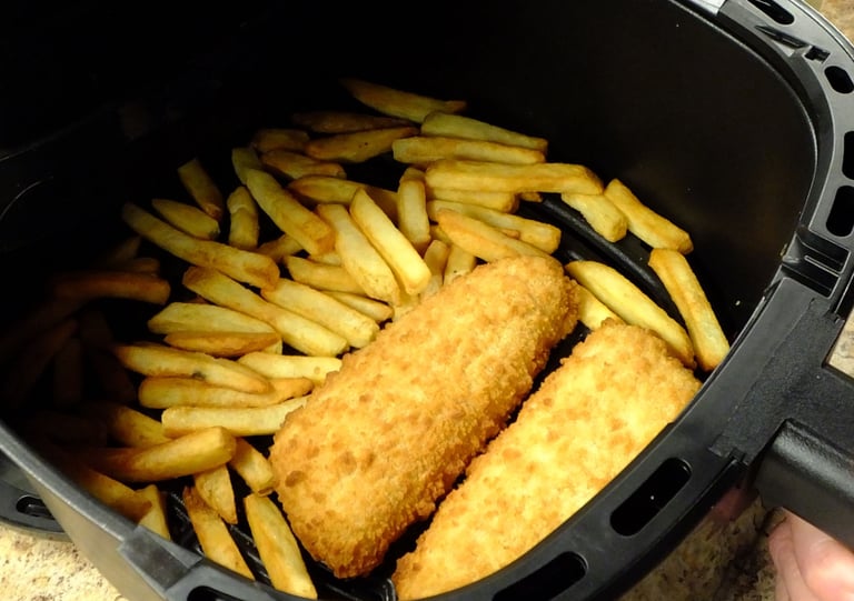 a person holding a fry fryer in a fryer