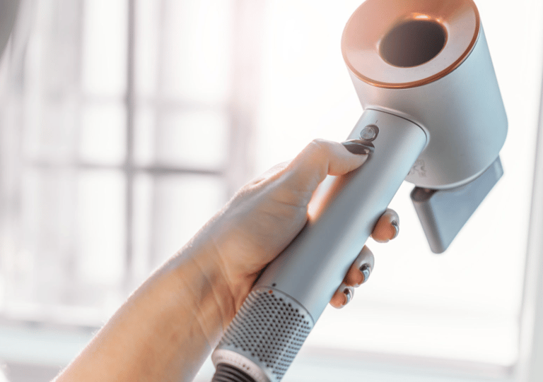 a woman is holding a hair dryer in her hand