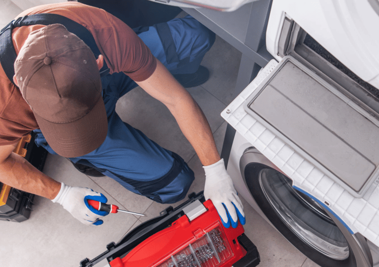 a man in a red shirt is fixing a washing machine
