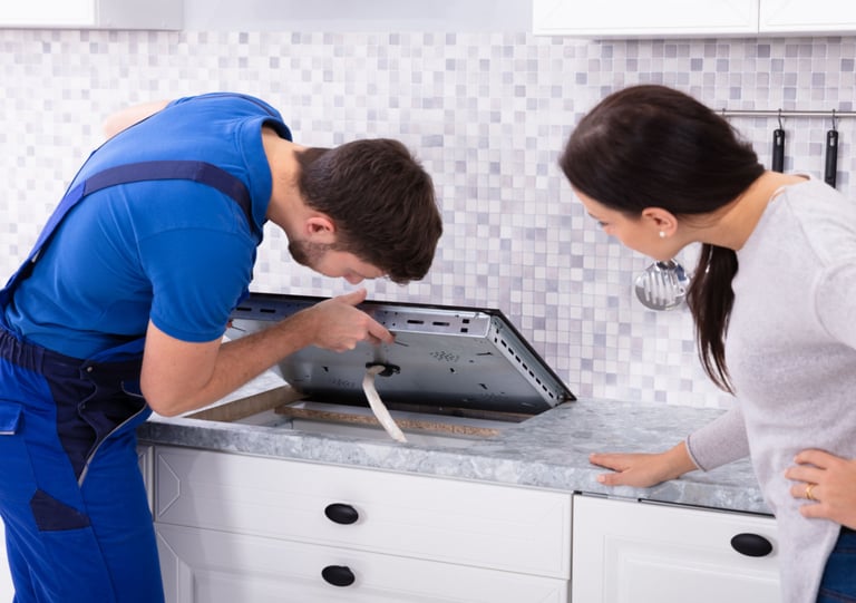 a man and woman in a kitchen with a stove top