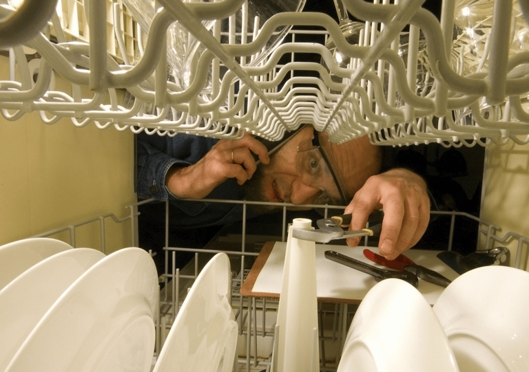 a man in a kitchen with a dishwasher and a dishwasher