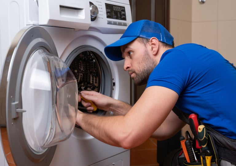 a man in a blue shirt is fixing a washing machine