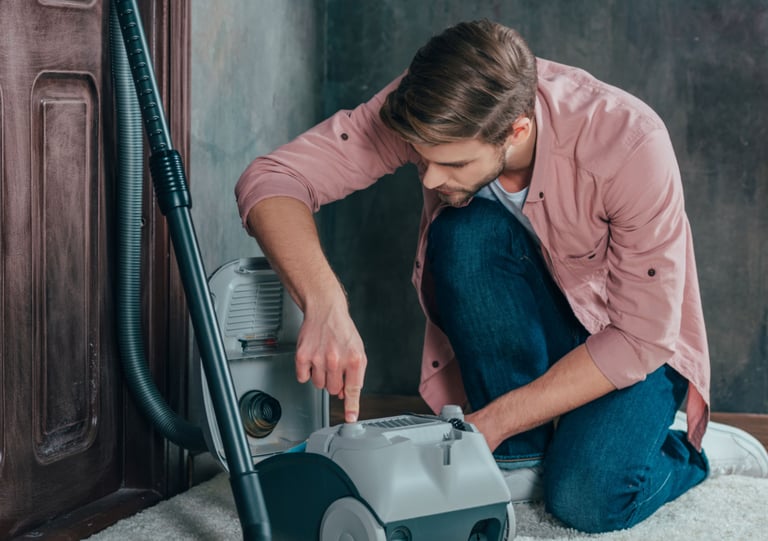 a man is cleaning a carpet with a vacuum