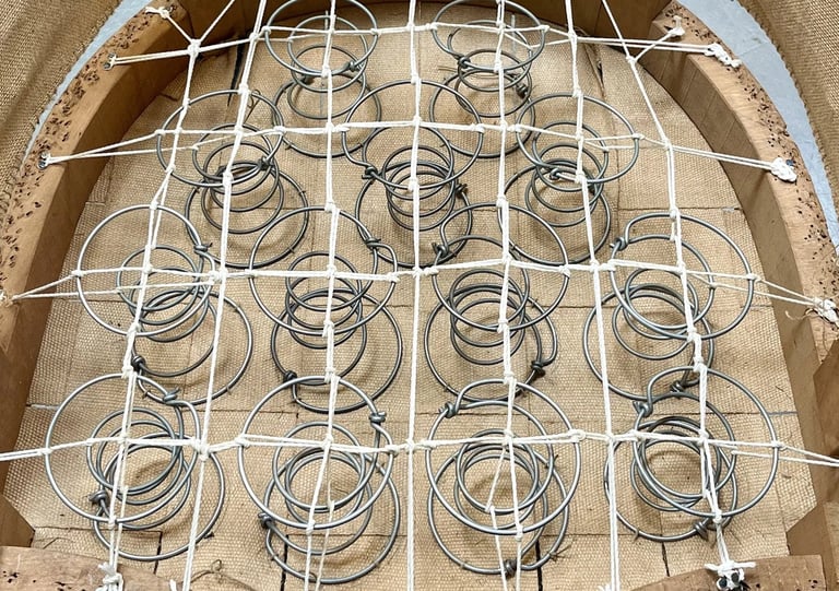 Carcasse d'un fauteuil crapaud avec sur le sanglage des ressorts guindés par des cordes