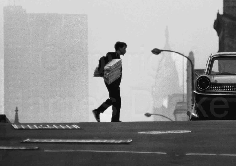 A newsboy crosses the street in Center City Philadelphia in the 1960s by James Drake