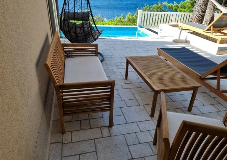 The photo shows a club set, deck chairs and an unobstructed view of the sea.