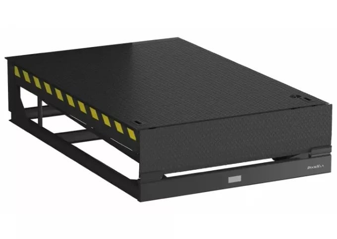 Industrial black mechanical dock leveler for loading bay with yellow safety stripes.