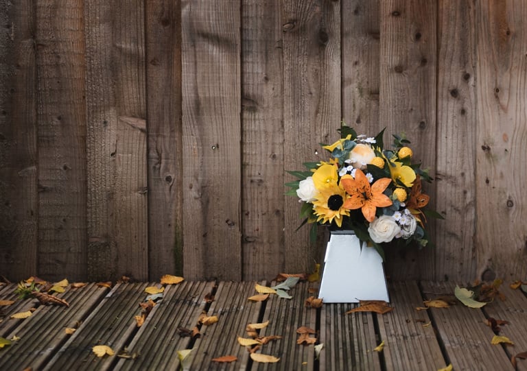 a vase with flowers in a vase on a wooden floor