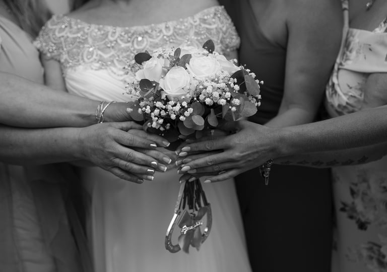 black and white image of bride and bridesmaids holding flowers