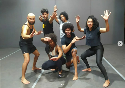a group of people standing around a man in a black shirt