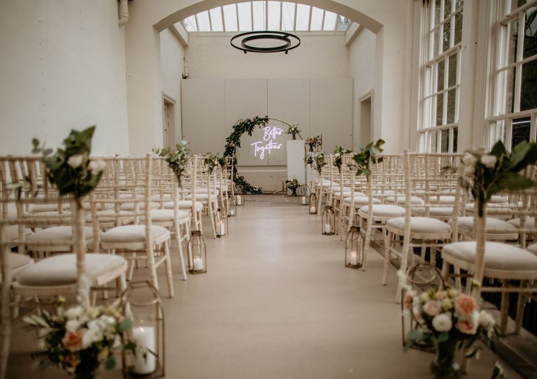 a wedding ceremony with a large window and flowers