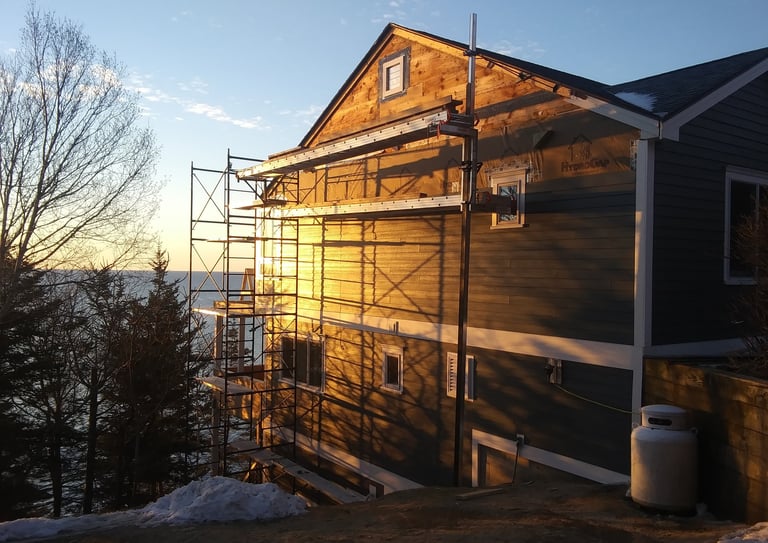three story house getting vinyl siding put on
