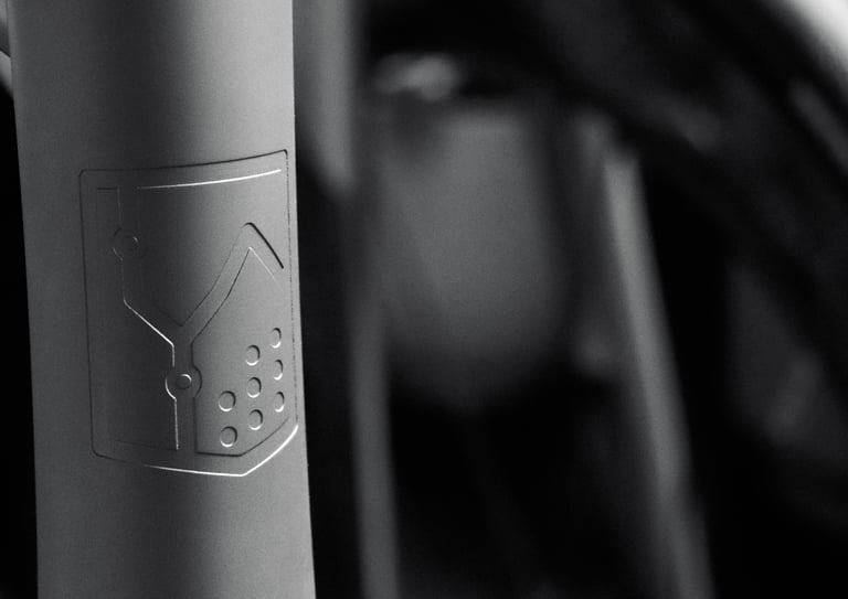 Dystrict logo engraved logo on titanium bicycle frame head tube.