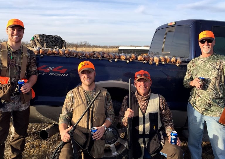 A group of four hunters celebrating a successful day of bird hunting in the Texas Panhandle.