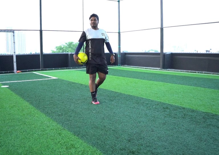 a man in a black shirt and shorts playing soccer