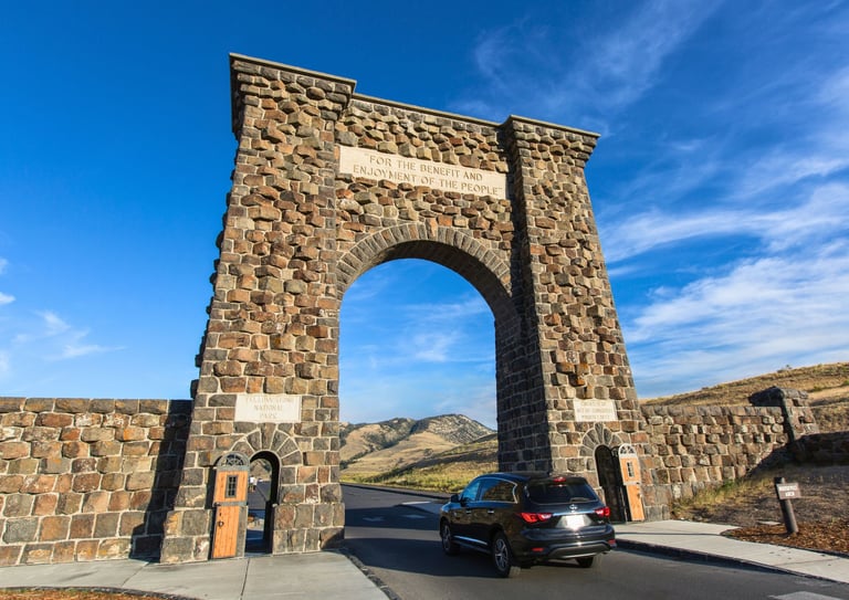 a car driving through a stone arch
