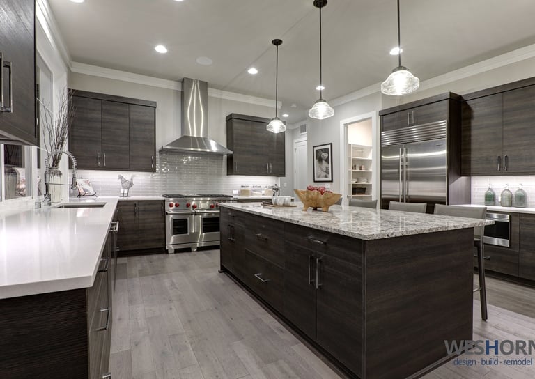 Sleek kitchen featuring dark wood cabinets and stainless steel appliances.
