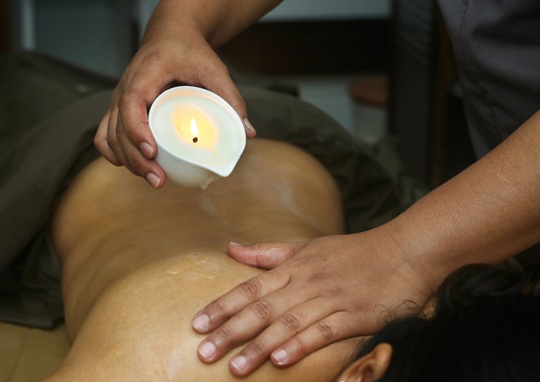 Professional therapist performing a relaxing candle wax massage on a client's back at a luxury spa.