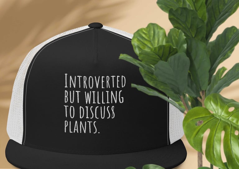 Black and white trucker hat with “Introverted but willing to discuss plants” text — Miss Chatty Plants.