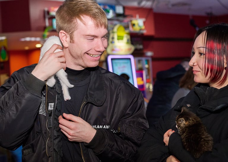 a man and woman holding a kitten in a lobby