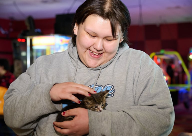 a woman holding a kitten in her hands