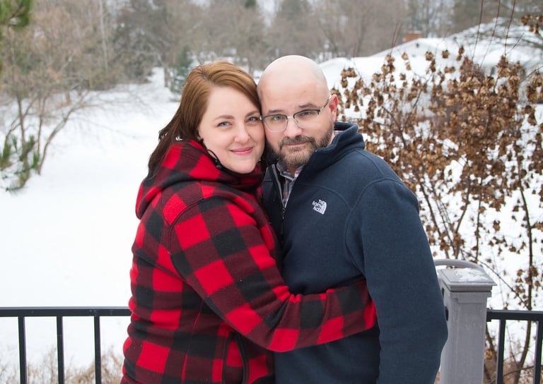 a man and woman standing in the snow