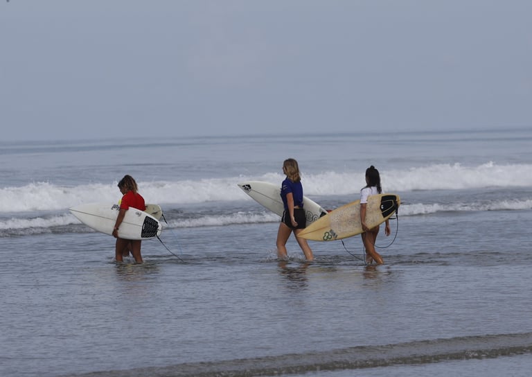Group of surfer girls entering the water
