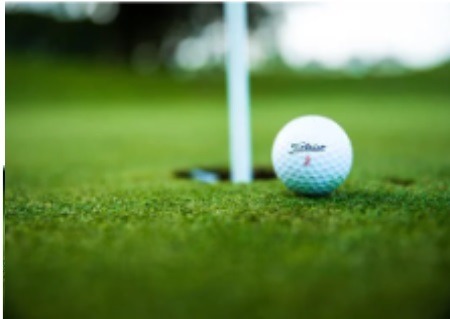 a golf ball sitting on the ground next to a golf ball