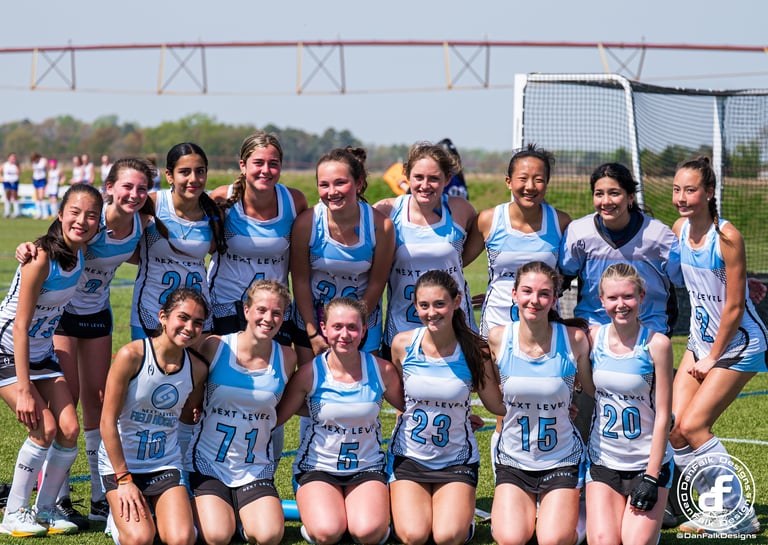 a group of girls field hockey players posing for a picture