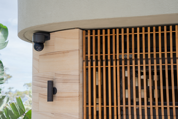 a camera mounted to a wall near a building