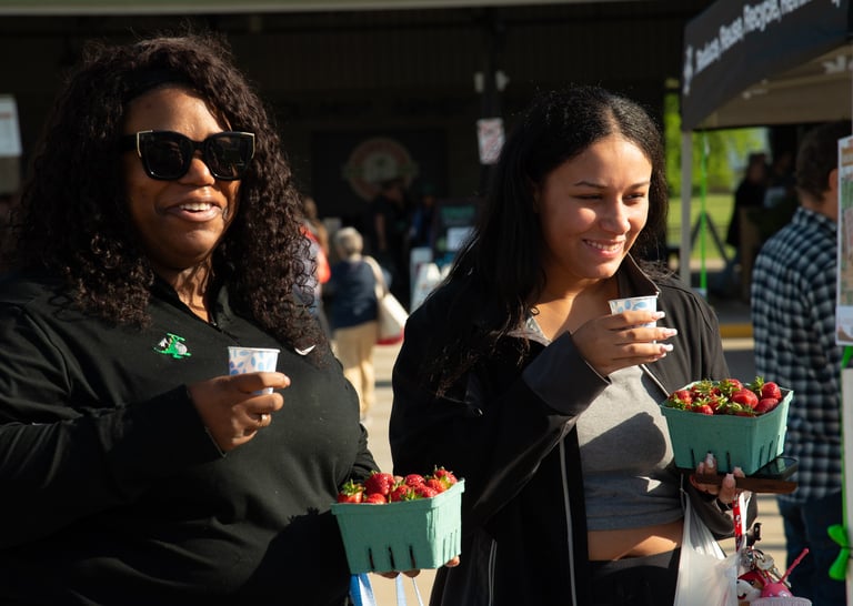 Two adults leaving the farmers market enjoying our bike-powered smoothies