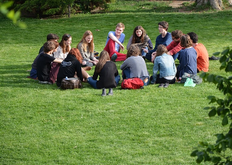 Groupe de personnes assis en cercle sur l'herbe