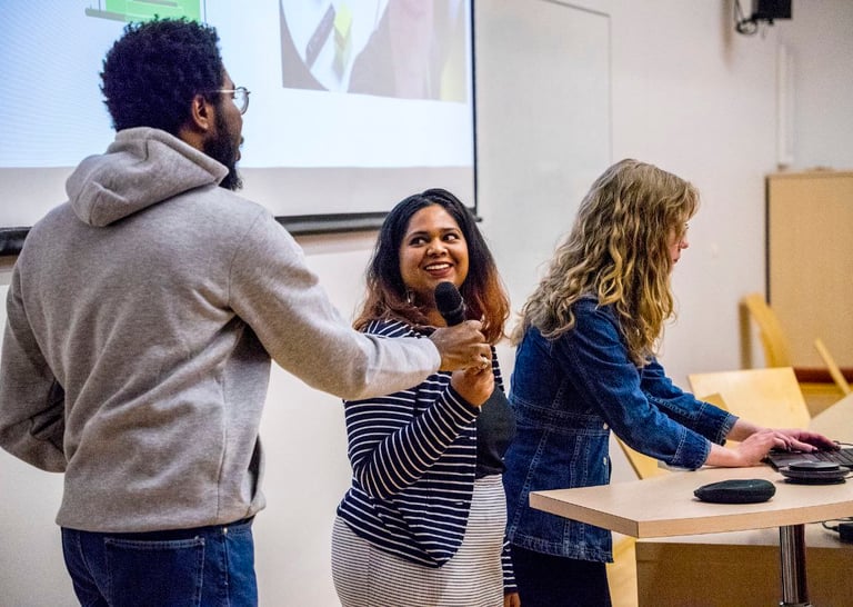 Троє дослідників людей на презентації проєкту. Діана на фоні гортає презентацію.