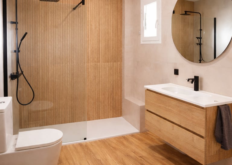 Reforma de baño moderno con plato de ducha a ras y mampara fija en Sevilla