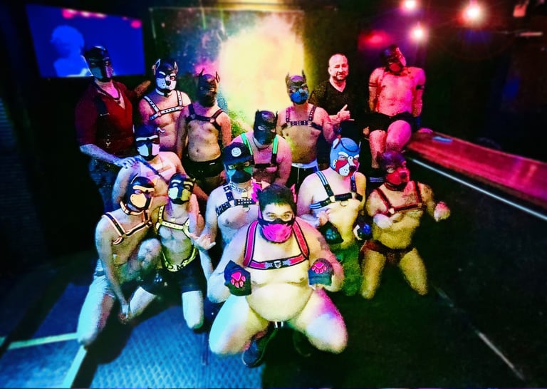 A group of men in pup masks posing for a group photo in a club