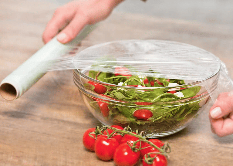 a person is holding a plastic container with tomatoes