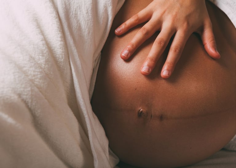 a pregnant woman with her belly in bed