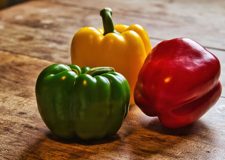 three peppers peppers on a wooden table