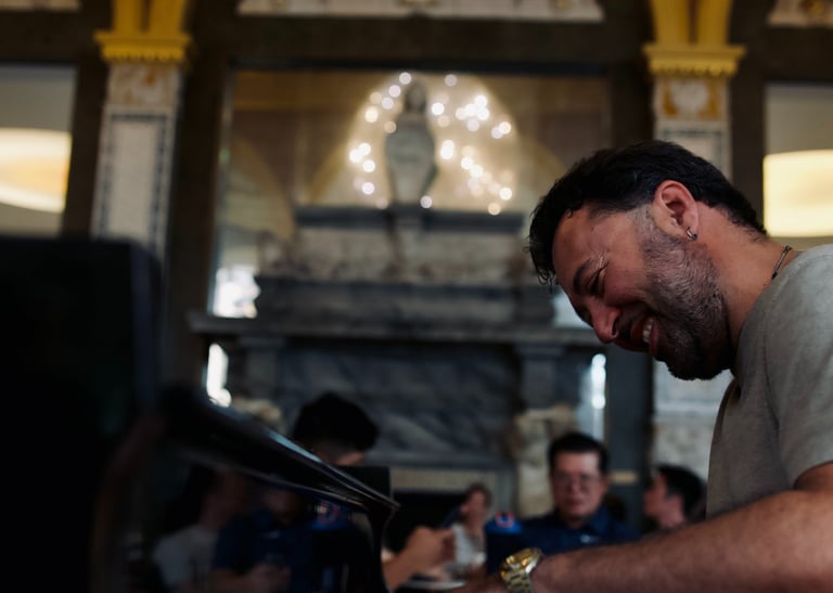 a man playing a piano in a room with a chandelier