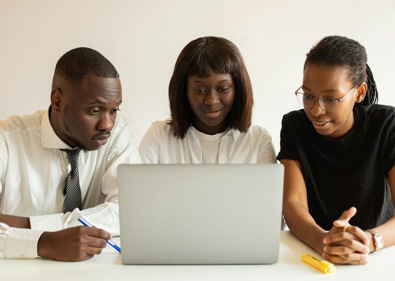 a man and woman sitting at a table with a laptop
