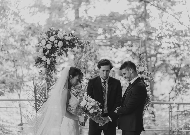 Caleb Postlewait leading prayer for Matt and Kyle Kloet's wedding ceremony