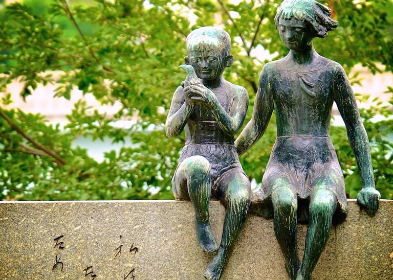 a couple of statues sitting on a stone wall