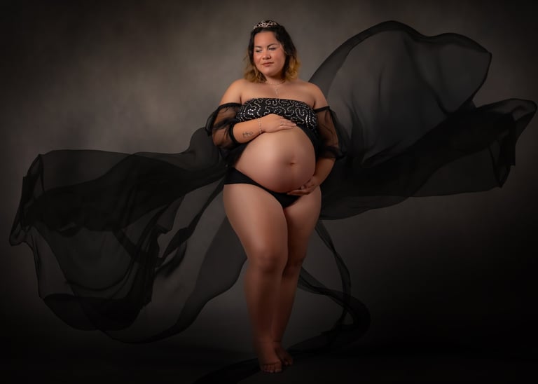 a pregnant woman in a black dress with a veil